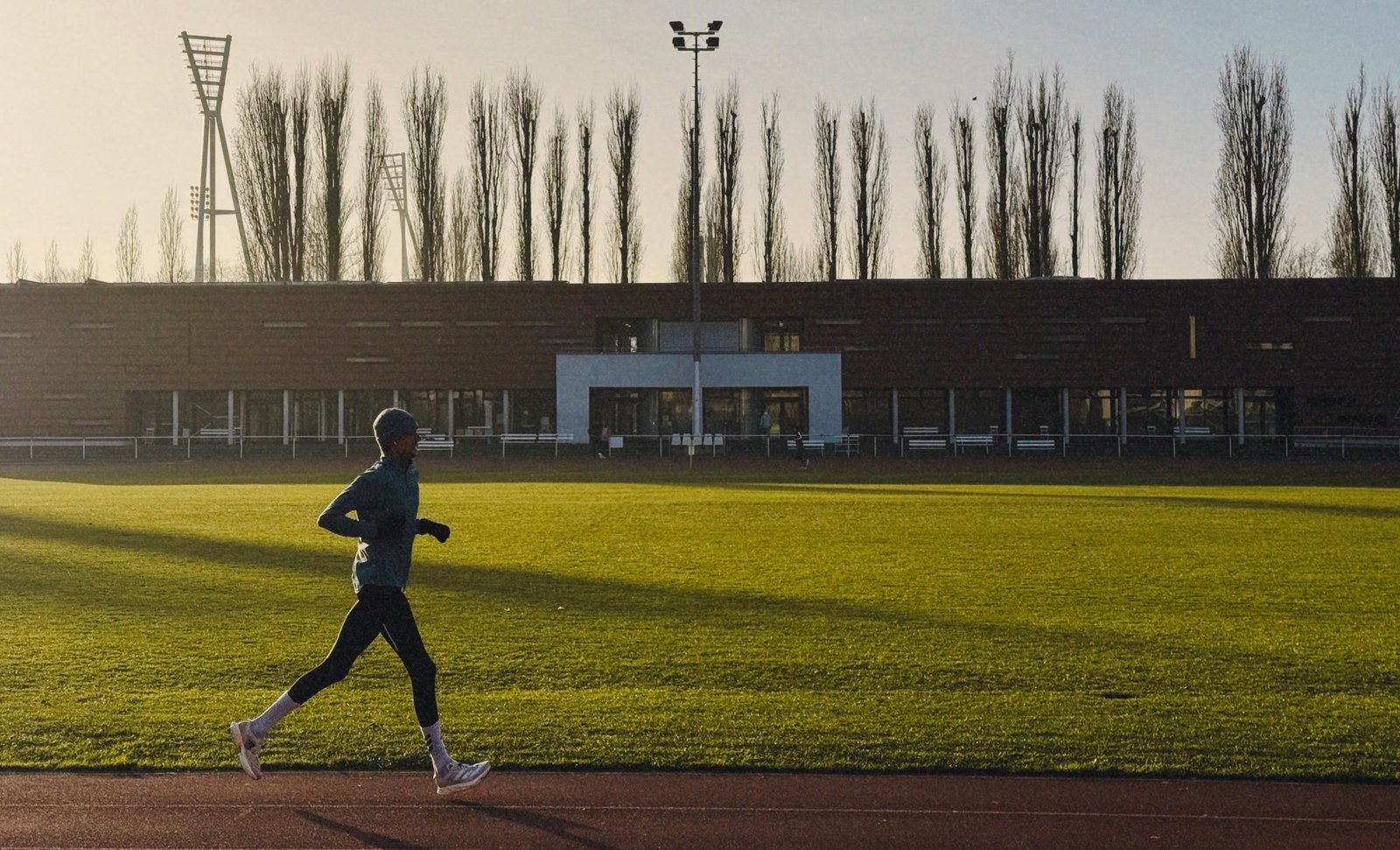 Coureur en pleine séance de fractionné sur piste au lever du soleil